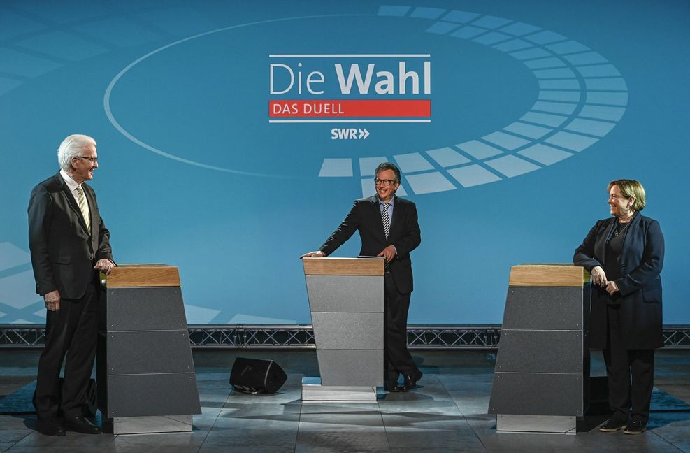 Beim Live-Duell im SWR stehen die beiden baden-württembergischen Spitzenkandidaten zur Landtagswahl, Ministerpräsident Winfried Kretschmann (Grüne, l.) und Susanne Eisenmann ( CDU) vor der Sendung im Wahlstudio zusammen mit Moderator Fritz Frey (Mitte). Foto: dpa/Patricia Neligan