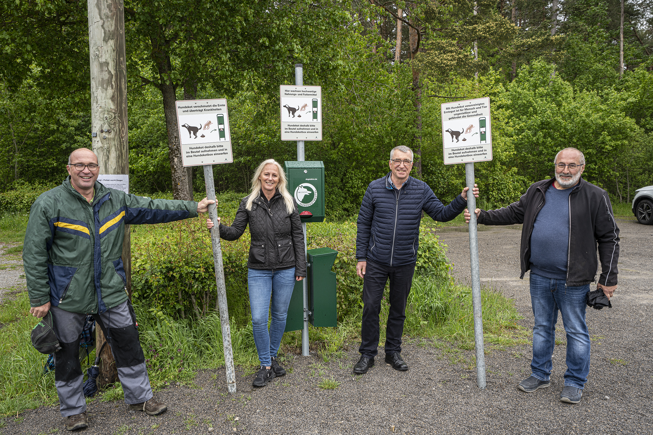 An zwölf Standorten mit Hundetoiletten in der Gesamtgemeinde Aidlingen werden die neuen Schilder für den Gebrauch der Kotbeutel aufgestellt, wie hier auf dem Wanderparkplatz auf dem Venusberg. Auf unserem Foto von links: Landwirt Thomas Rott, Grafikdesignerin Maggie Jarak, Bürgermeister Ekkehard Fauth und Landwirt Eberhard Breitling. Bild: Richter
 Richter