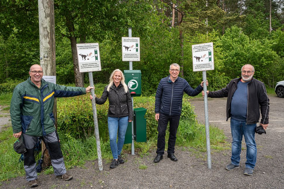 An zwölf Standorten mit Hundetoiletten in der Gesamtgemeinde Aidlingen werden die neuen Schilder für den Gebrauch der Kotbeutel aufgestellt, wie hier auf dem Wanderparkplatz auf dem Venusberg. Auf unserem Foto von links: Landwirt Thomas Rott, Grafikdesignerin Maggie Jarak, Bürgermeister Ekkehard Fauth und Landwirt Eberhard Breitling. Bild: Richter
 Richter