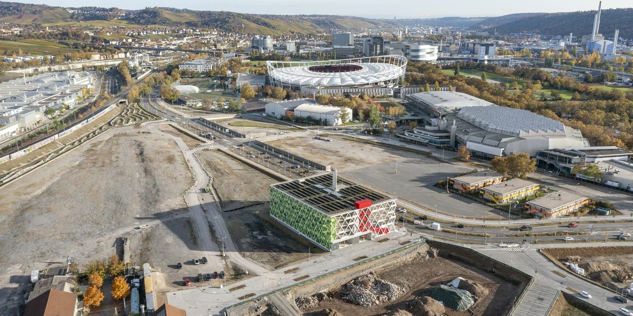 Noch herrscht drumherum Leere: das Quartiersparkhaus Q16 mit integrierter Energiezentrale im Neckarpark markiert prominent den Zugang zum neuen Quartier Neckarpark in Bad Cannstatt.  Am unteren linken Bildrand das Stadtarchiv Stuttgart, oben rechts sieht man Porschearena und Schleyerhalle, links davon die  Mercedes Benz  Arena.