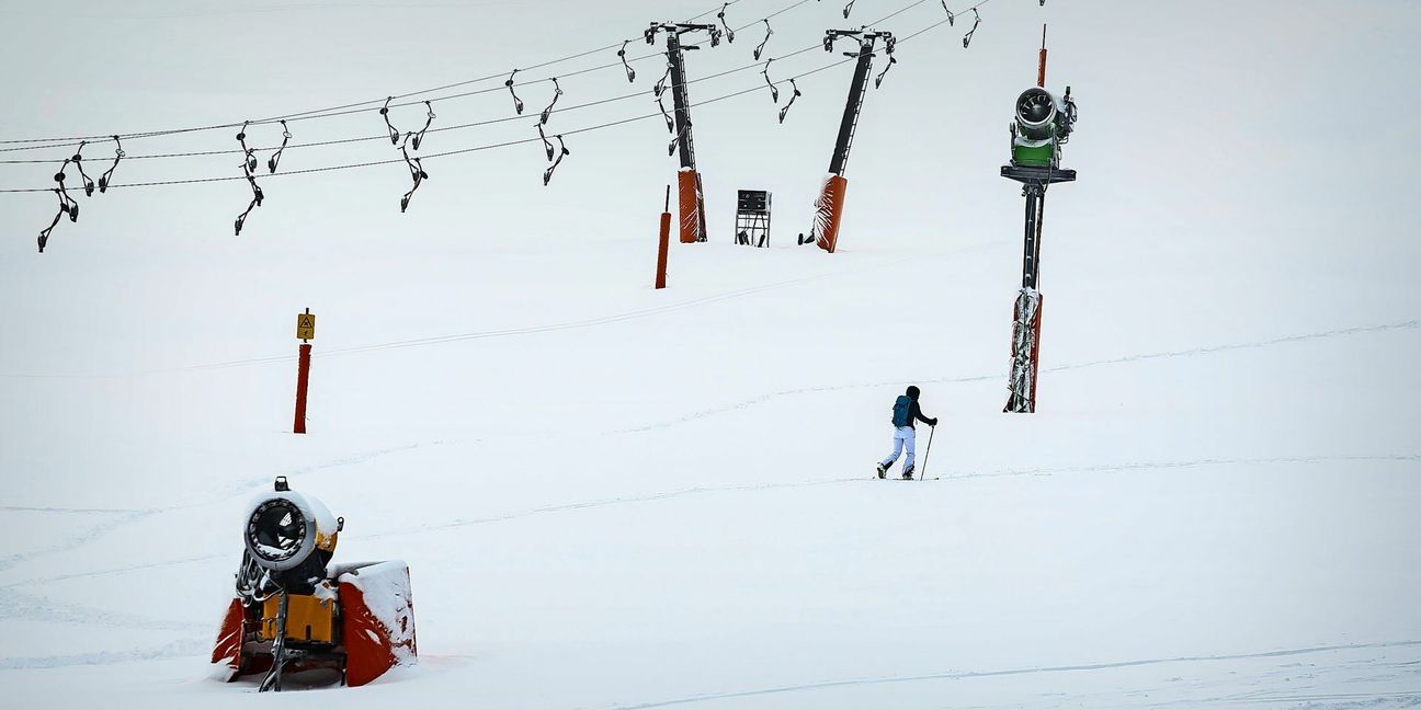 Eine Skitourengeherin läuft an einem stillgelegten Lift auf dem Feldberg vorbei.