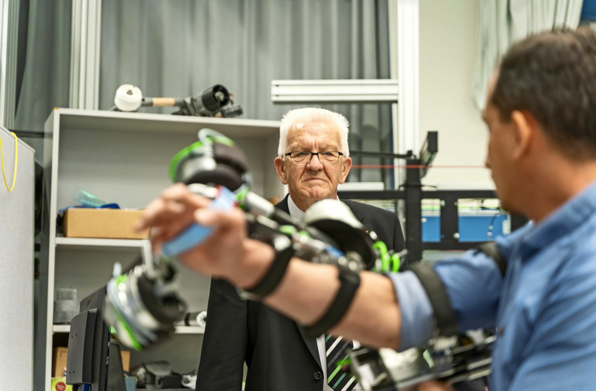 Winfried Kretschmann lässt sich  Assistenzsysteme für Schlaganfallpatienten vorführen.