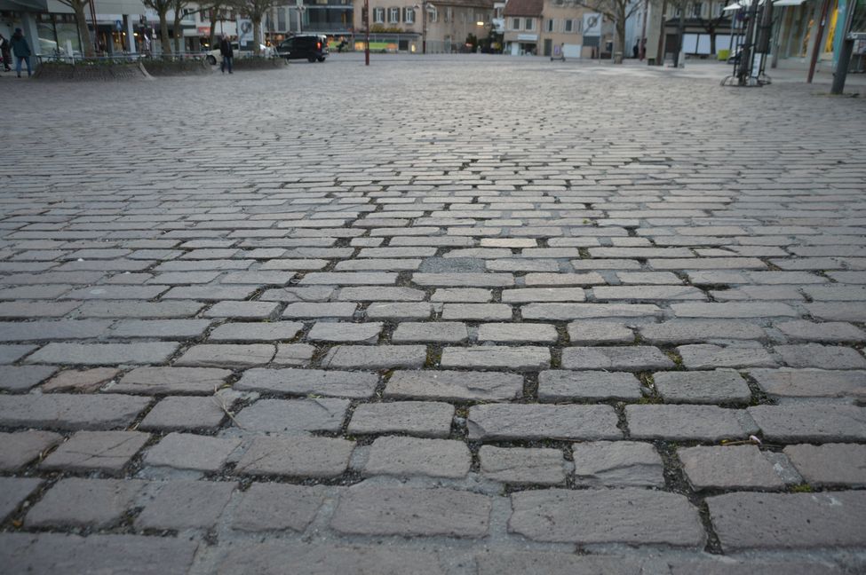 Bei den großen Pflastersteinen auf dem Marktplatz werden die breiten Rillen schnell zum Ärgernis für Rollstuhlfahrer. Bild: Groß