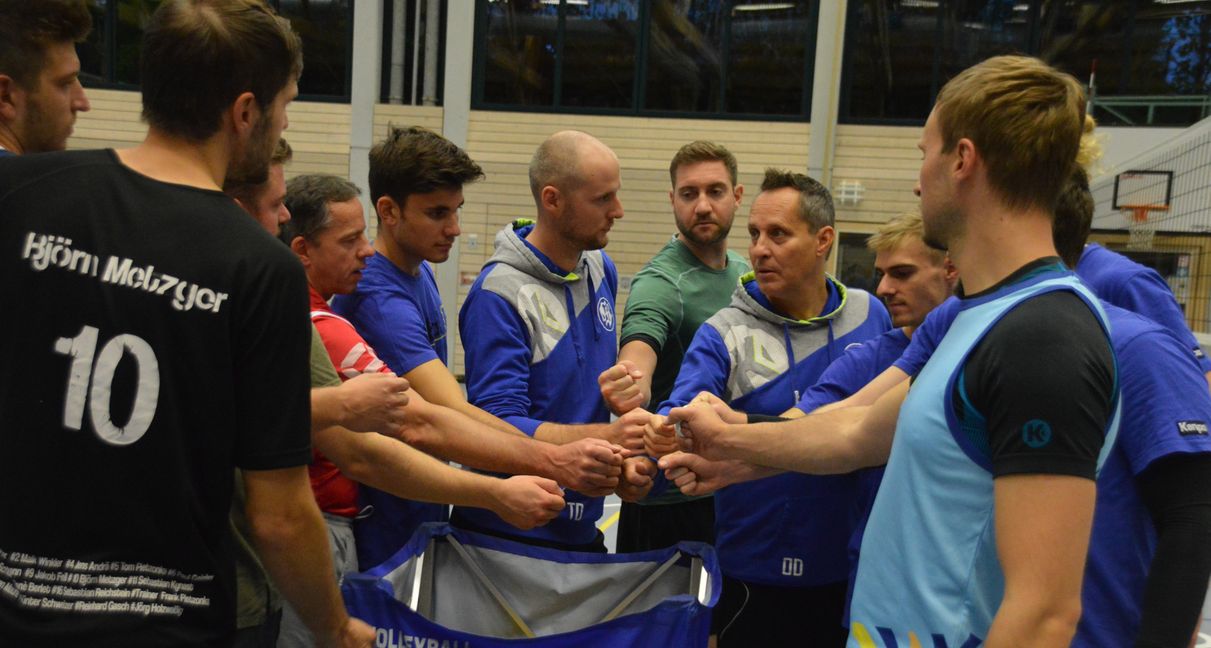 Trainer Oliver Dostal (Mitte, melierte Haare) und sein neuer Co-Trainer Simon Sturm (rechts daneben) stimmen das Team vor dem Abschlusstraining am Mittwochabend in der Sporthalle Stadtmitte ein. Bild: Wegner