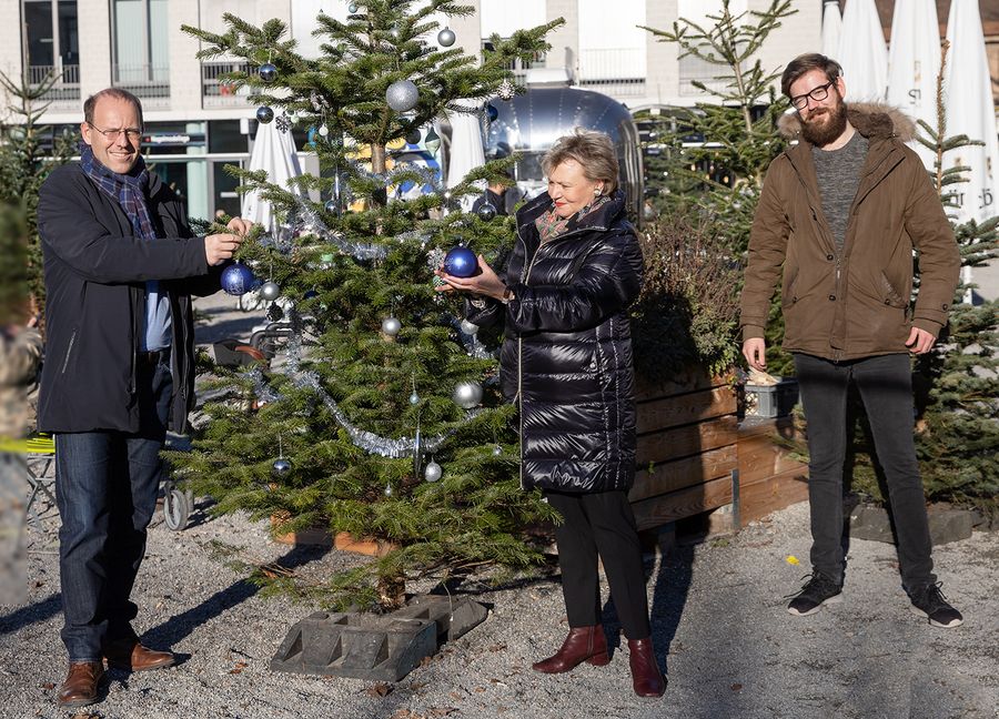 Oberbürgermeister Dr. Bernd Vöhringer, Sabine Duffner von der ARGE Grüner Platz und Citymanager Jan Gaiser schmücken bei schönstem Winterwetter den ersten Baum.