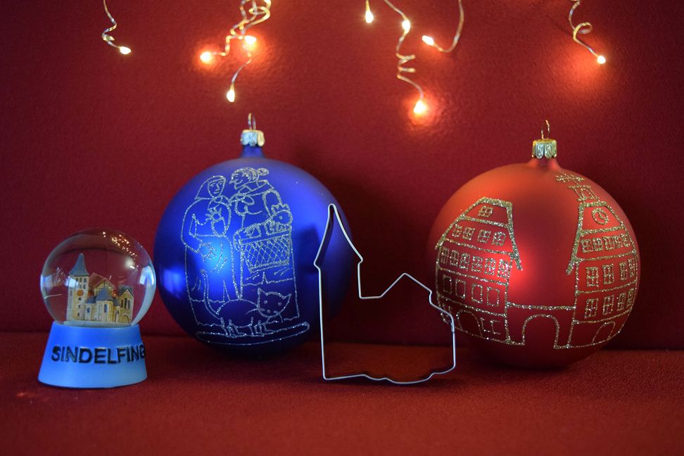 Das Sindelfinger Weihnachts-Merchandisingprogramm: Weihnachtskugeln mit den Motiven „Schwätzweiber“ und „Stadtmuseum“ und die Martinskirche in einer Schneekugel oder als Ausstechform.   Bild: Wirtschaftsförderung Sindelfingen GmbH
 z
