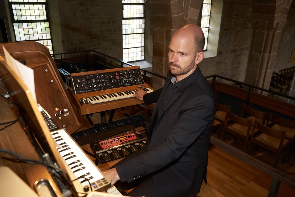 Organist, Pianist und Komponist Sebastian Bartmann spieplt in der der Sindelfinger Martinskirche an Synthesizer und Weigle-Orgel.    Bild: Heiden