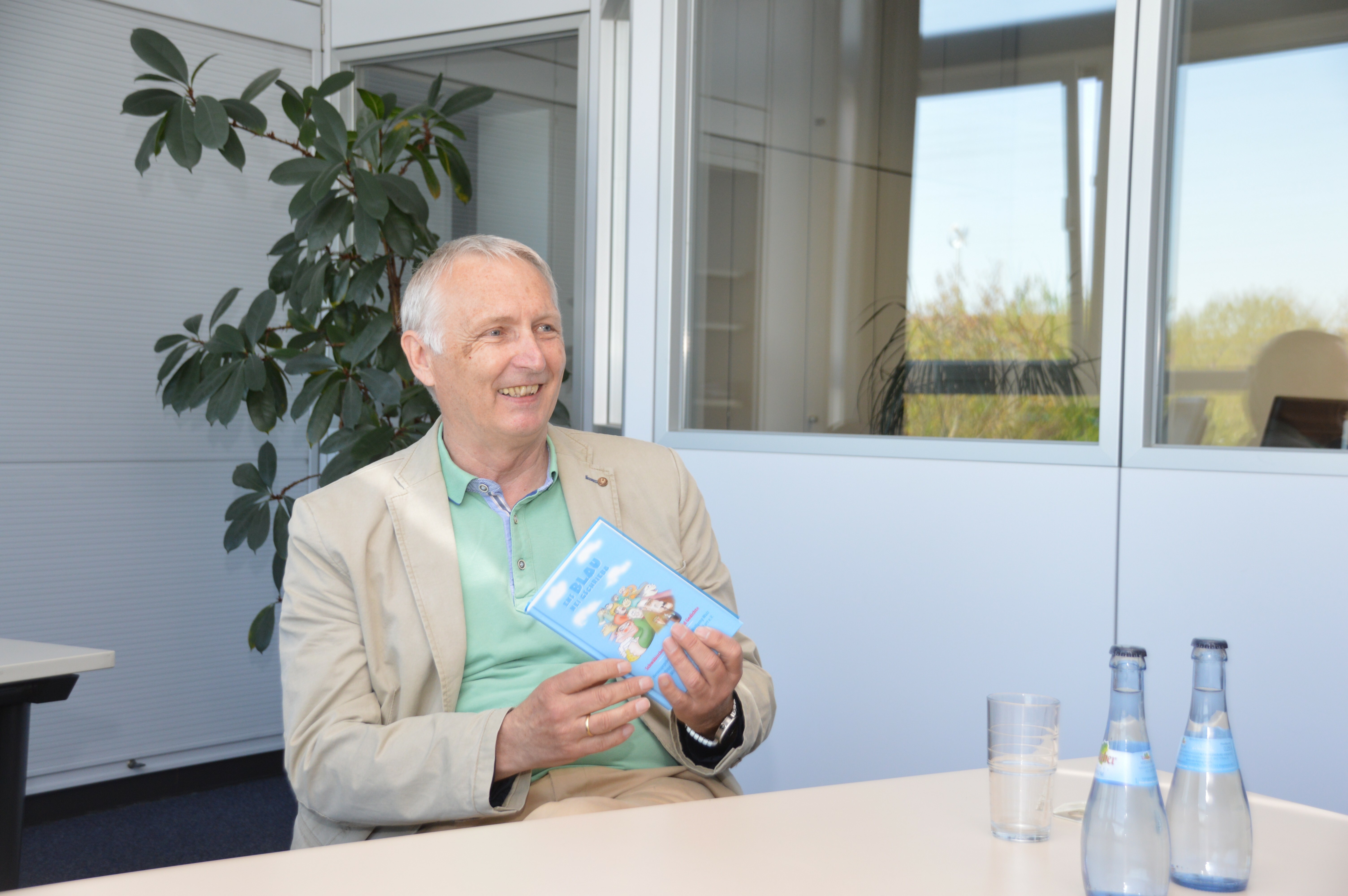 Dr. Wolfgang Wulz uns sein neuestes Buch „Ens Blau nei gschrieba“.  Bild: Hansjörg Jung