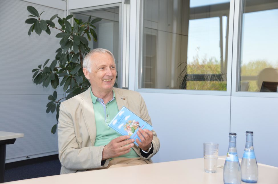 Dr. Wolfgang Wulz uns sein neuestes Buch „Ens Blau nei gschrieba“.  Bild: Hansjörg Jung