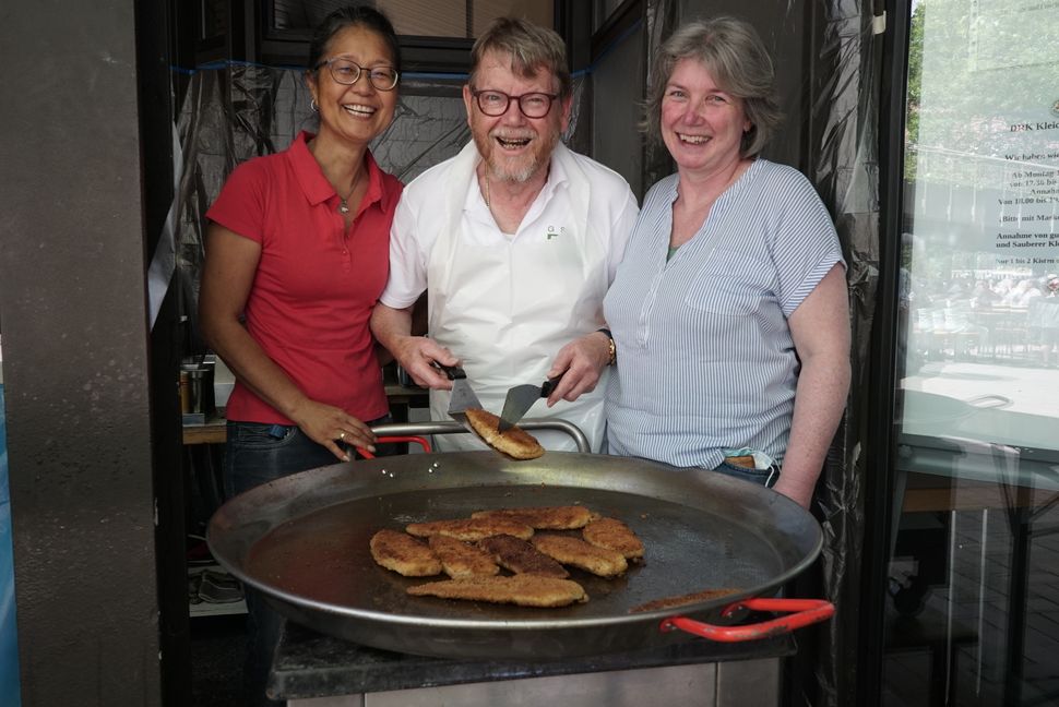 Backfisch zur Hocketse: Pfannenchef Reinhard Jensen kümmert sich um Filets, Cora-Suyin Müller und Kristine Seidl um die Führung der GSV-Chöre.   Bild: Heiden
