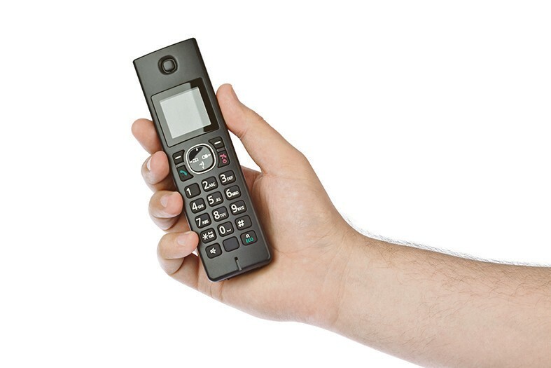 Hand with wireless radio telephone isolated on white background