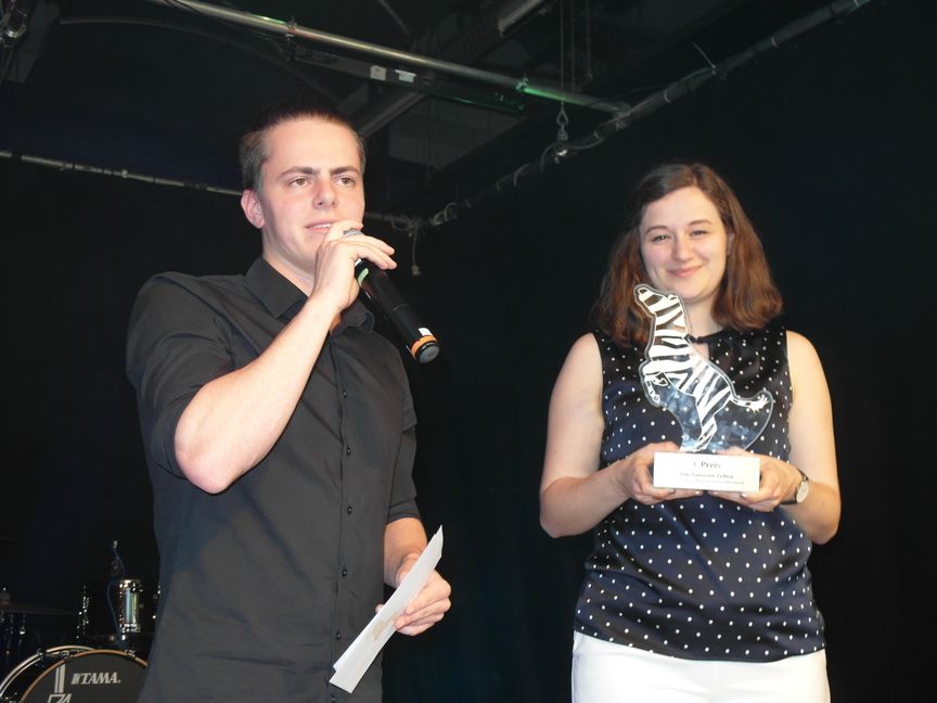 Die Moderatoren Nils Weber (links) und Leonie Rothacker vom veranstaltenden Verein Biennale Co. präsentieren die namensgebende Trophäe des Kleinkunstwettbewerbs "Das goldene Zebra".