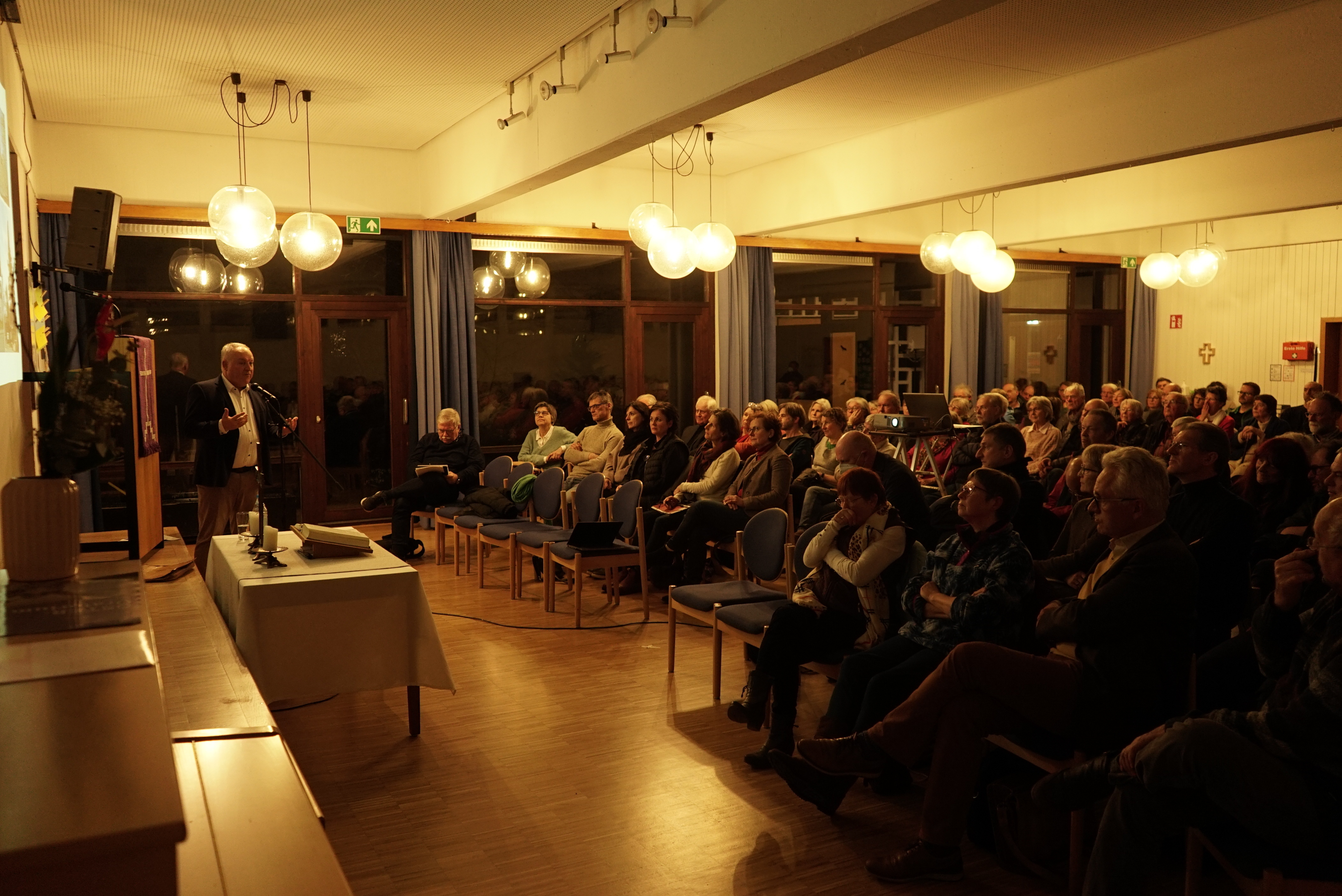 Pfarrer Jens Junginger (links) gibt auf einer Gemeindeversammlung bekannt, von welchen Gebäuden sich die Kirche trennt.    Bild: Heiden