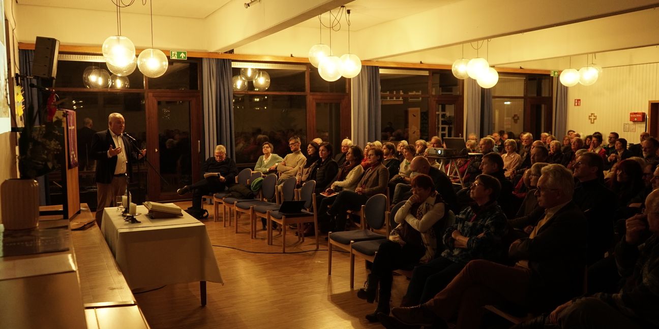 Pfarrer Jens Junginger (links) gibt auf einer Gemeindeversammlung bekannt, von welchen Gebäuden sich die Kirche trennt.    Bild: Heiden