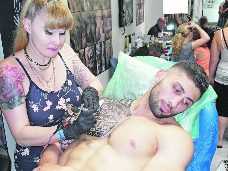 Manu Kelley tätowiert Antonios Kotseridis bei der Sindelfinger Messe. Bild: Staber