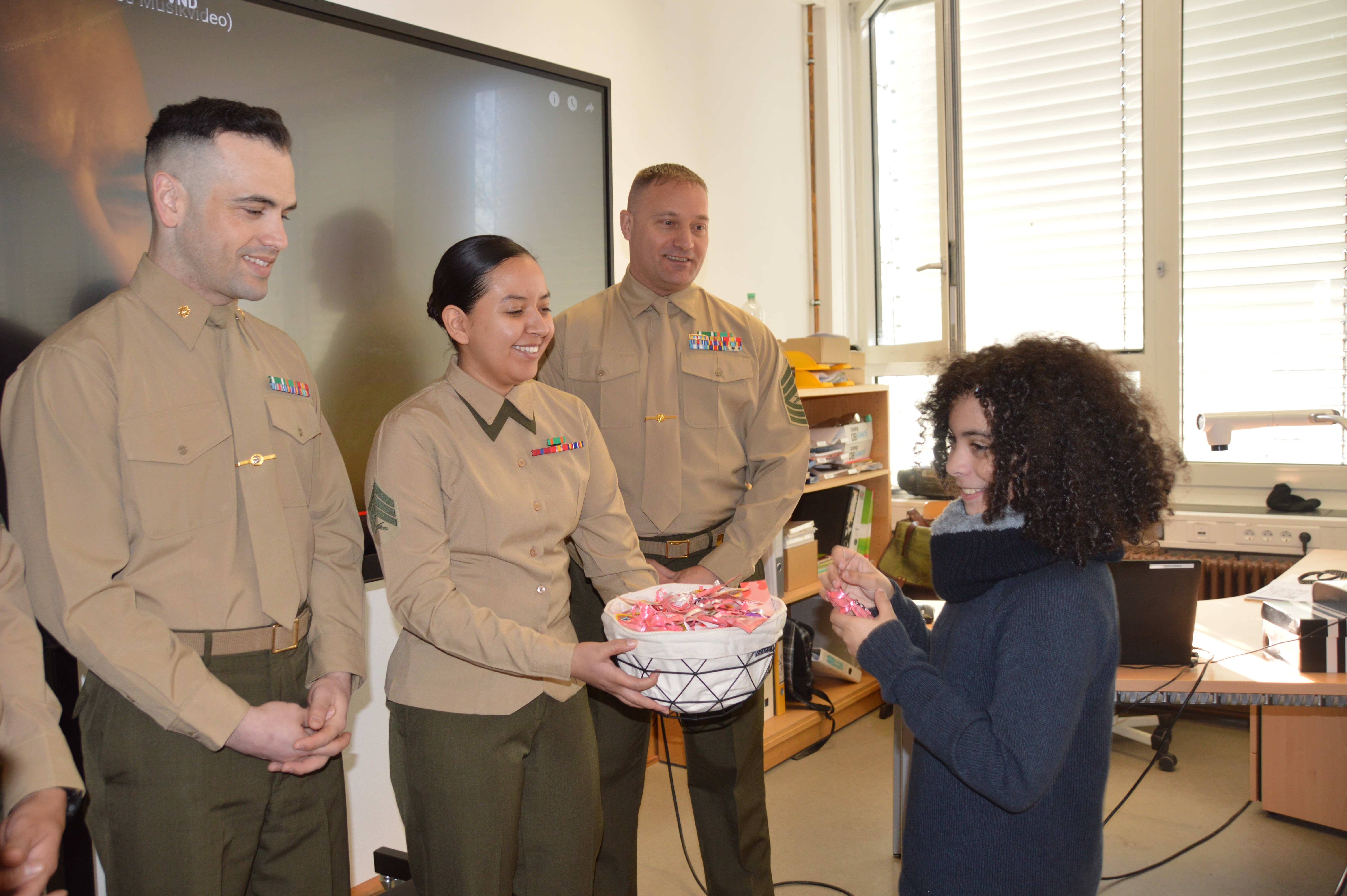 Major Patrick Anderson, Sergeant Rosalinda Ellinois und Master Segeant Andrew Wentworth verteilen Süßigkeiten an die Kinder. Bild: Greck